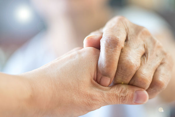 Caregiver, Specialized Assistance, carer hand holding elder hand woman in hospice care.
